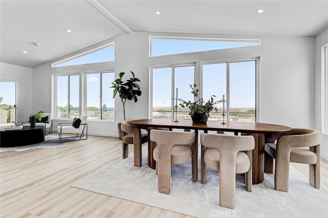 dining room featuring vaulted ceiling and light hardwood / wood-style flooring