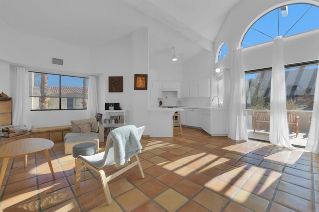 living room with sink, high vaulted ceiling, and light tile patterned floors