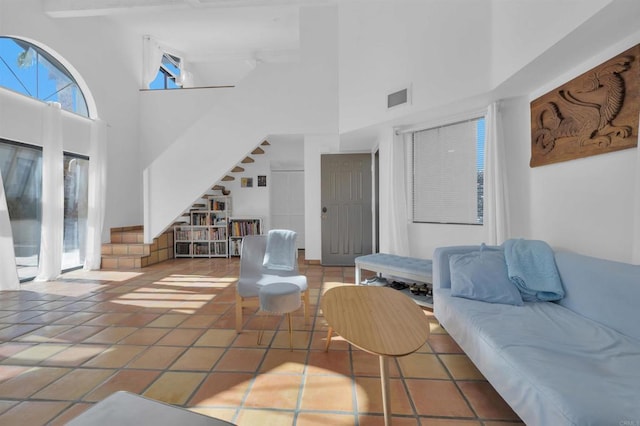 tiled living room with a high ceiling and beamed ceiling