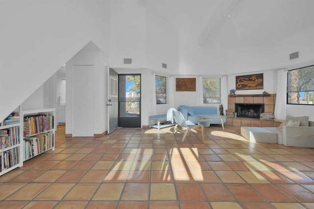 living room with a towering ceiling, tile patterned floors, and a fireplace