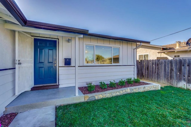 doorway to property with a lawn