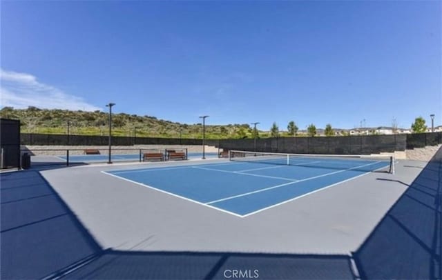 view of tennis court with basketball hoop