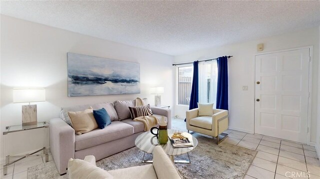 tiled living room featuring a textured ceiling