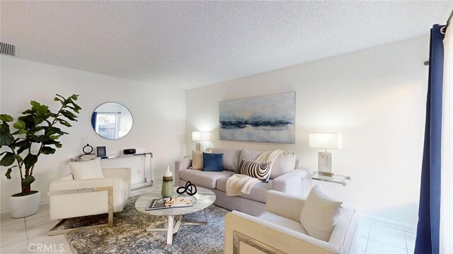 living room featuring light tile patterned floors and a textured ceiling