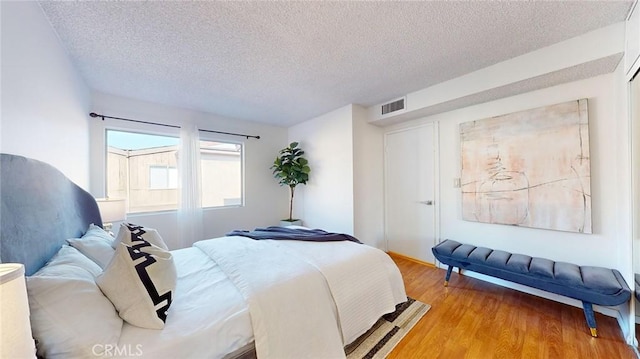 bedroom with wood-type flooring and a textured ceiling