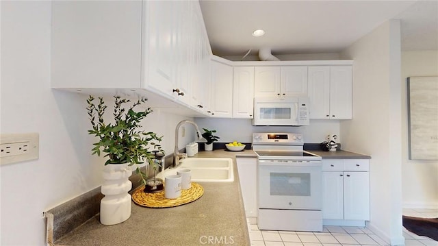 kitchen featuring sink, white appliances, light tile patterned floors, and white cabinets