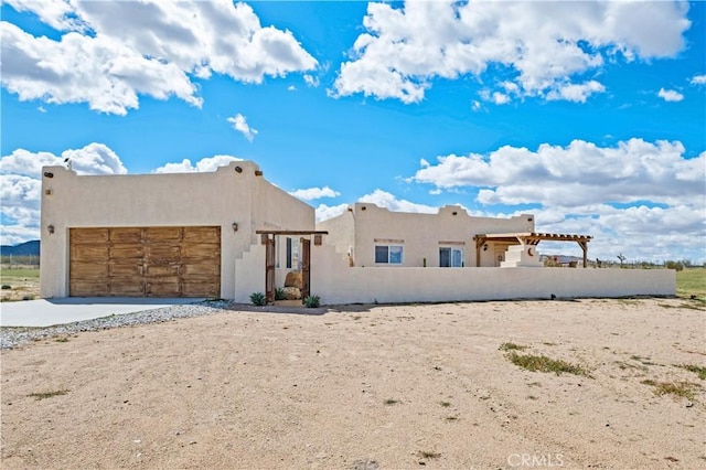 1388 Fortuna Ave, Landers, CA 92285 - pueblo revival-style home with an attached garage, stucco siding, and driveway