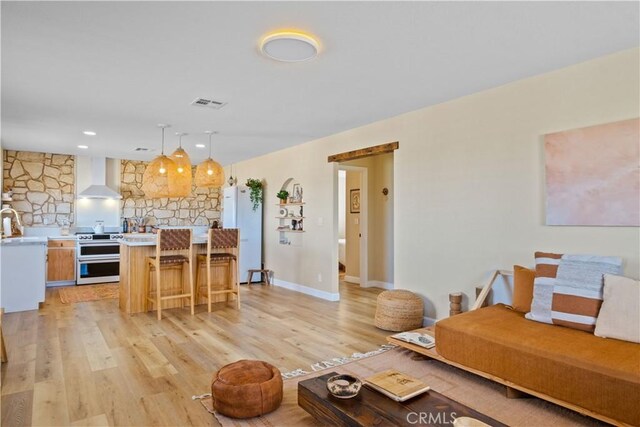 living room with light hardwood / wood-style flooring and sink