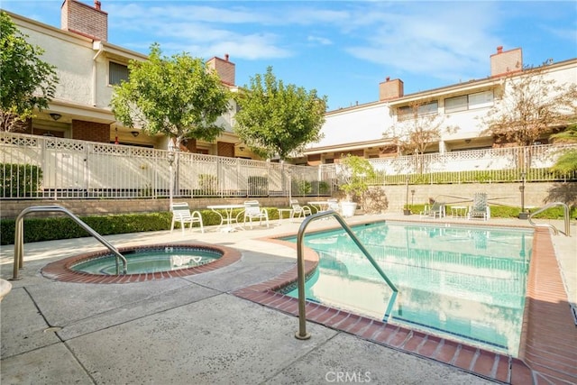 view of pool with an in ground hot tub and a patio