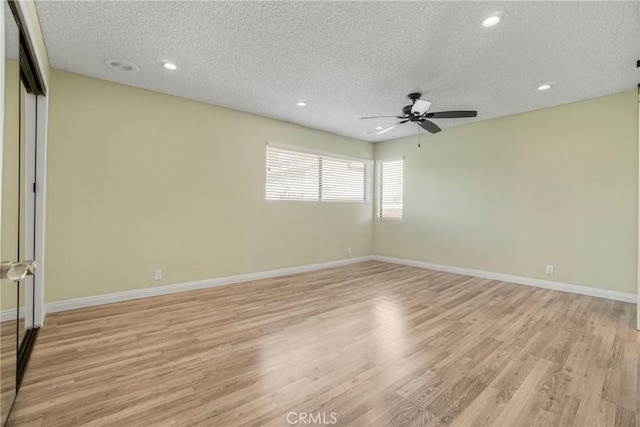 unfurnished room featuring a textured ceiling, ceiling fan, and light hardwood / wood-style flooring