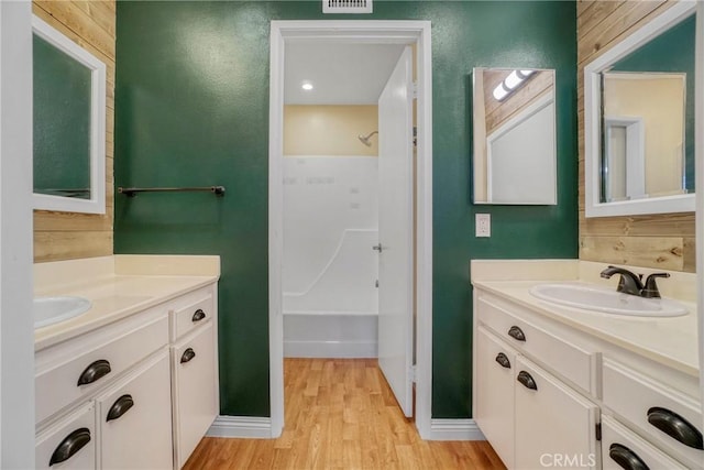 bathroom with wooden walls, vanity, and hardwood / wood-style flooring