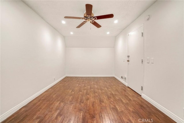 empty room featuring vaulted ceiling, ceiling fan, and hardwood / wood-style flooring