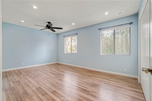 empty room featuring a textured ceiling, light wood-type flooring, and ceiling fan