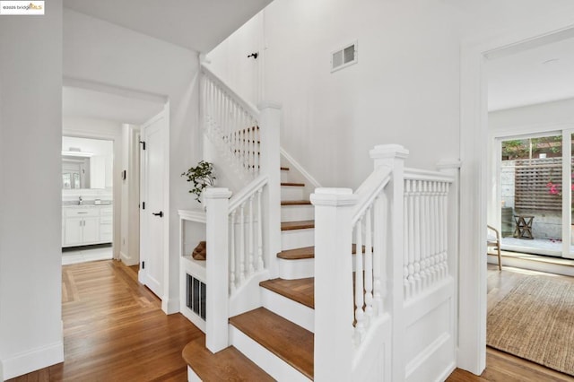 staircase with hardwood / wood-style floors