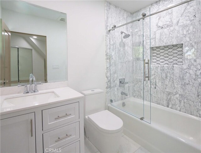 full bathroom featuring toilet, tile patterned flooring, combined bath / shower with glass door, and vanity