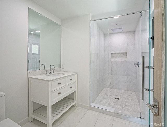 bathroom featuring tile patterned floors, a tile shower, and vanity