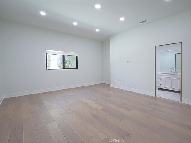 unfurnished room with light wood-type flooring and sink