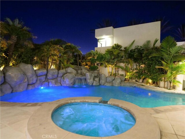 pool at twilight with an in ground hot tub