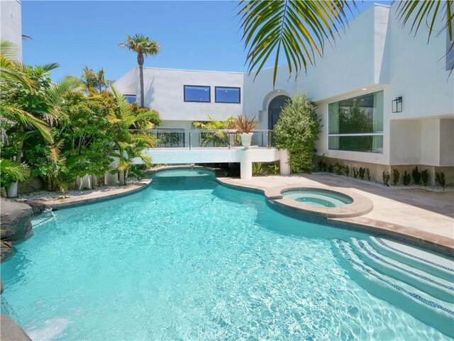 view of pool with an in ground hot tub