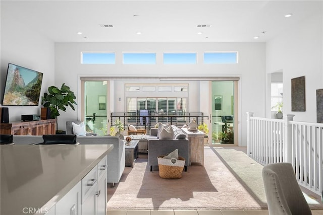 tiled living room with a high ceiling and a healthy amount of sunlight