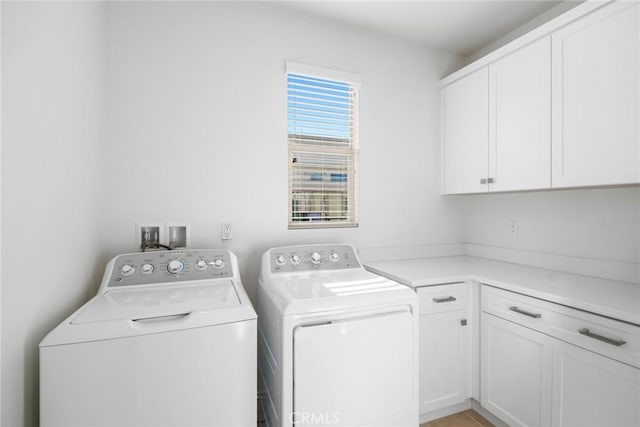 clothes washing area featuring washer and dryer and cabinet space