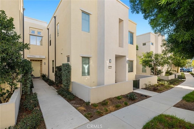 view of front of property featuring fence and stucco siding