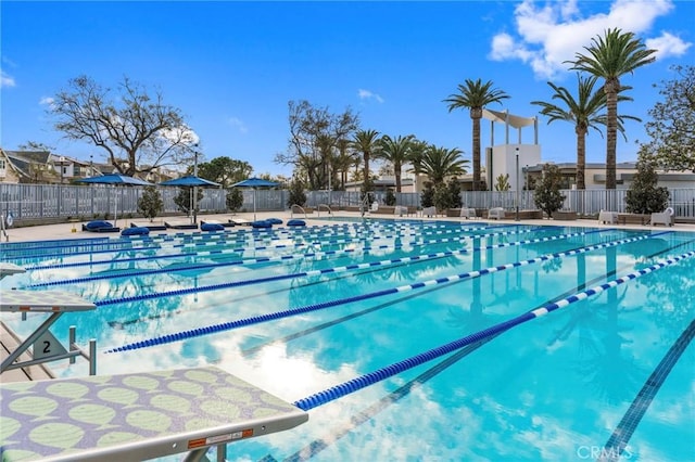 community pool featuring fence and a patio