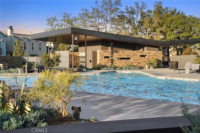 community pool featuring fence and a patio