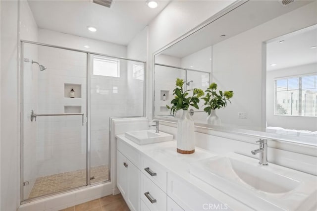 full bathroom with a stall shower, a sink, and a healthy amount of sunlight