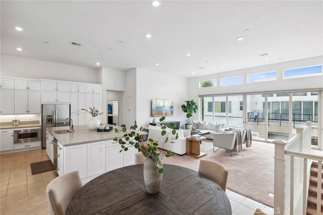 tiled dining room featuring a towering ceiling and sink