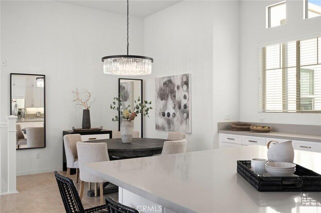 dining area with light tile patterned floors, a high ceiling, and a notable chandelier