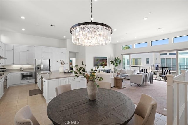 dining area featuring light tile patterned floors, a high ceiling, recessed lighting, and a notable chandelier