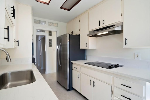 kitchen with white cabinets, black electric stovetop, stainless steel refrigerator with ice dispenser, and sink