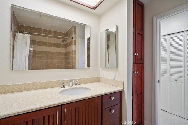 bathroom featuring walk in shower and vanity