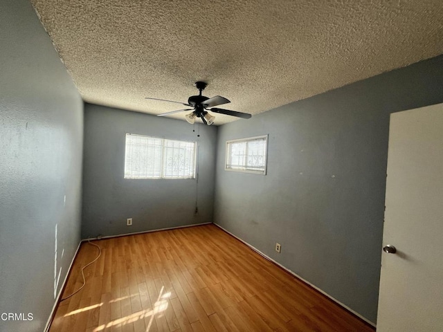 spare room featuring a textured ceiling, ceiling fan, and light hardwood / wood-style flooring