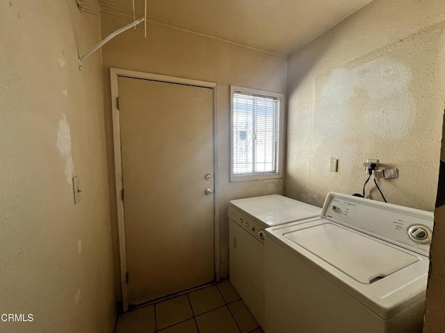 clothes washing area with dark tile patterned floors and washing machine and dryer