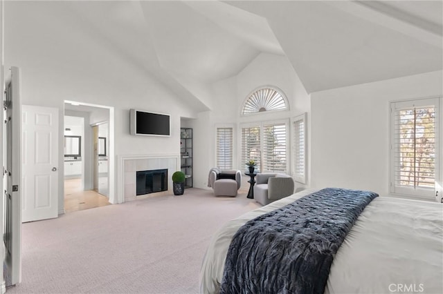 carpeted bedroom with high vaulted ceiling, a fireplace, and connected bathroom