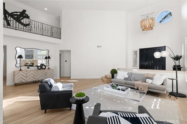 living room featuring a high ceiling, wood-type flooring, and a chandelier