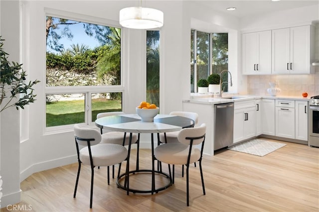 kitchen with stainless steel appliances, white cabinets, tasteful backsplash, and sink