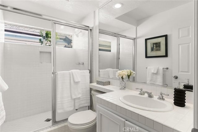 bathroom featuring toilet, an enclosed shower, and vanity