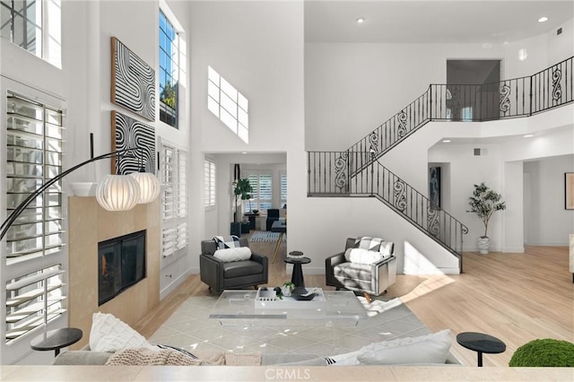 living room featuring a towering ceiling and light hardwood / wood-style flooring