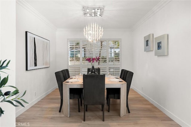 dining area featuring a chandelier, light hardwood / wood-style floors, and crown molding