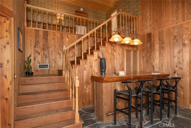 bar with wooden walls, wood ceiling, and hanging light fixtures