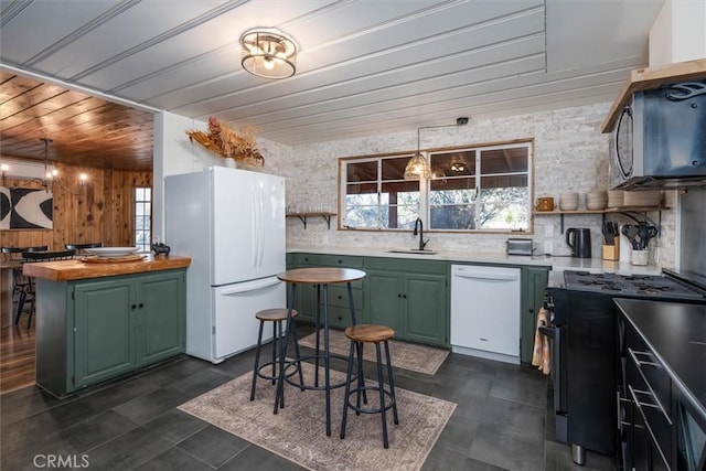 kitchen featuring white appliances, wooden counters, a healthy amount of sunlight, green cabinets, and sink