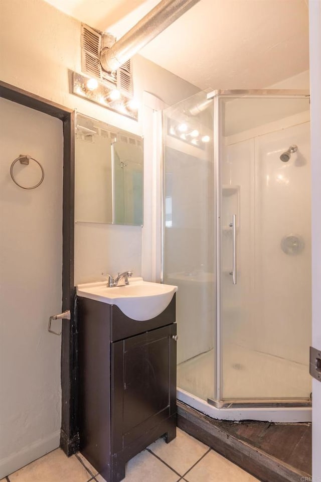 bathroom with a shower with door, tile patterned floors, and vanity