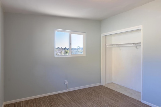 unfurnished bedroom with light wood-type flooring and a closet