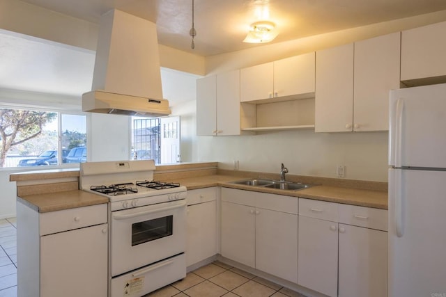 kitchen with white appliances, island exhaust hood, kitchen peninsula, white cabinets, and sink