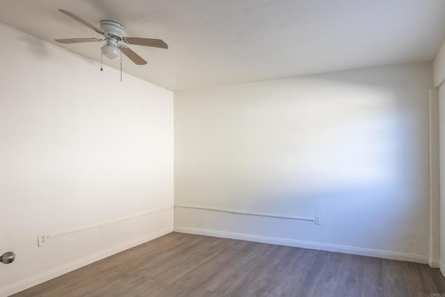 spare room featuring ceiling fan and dark wood-type flooring