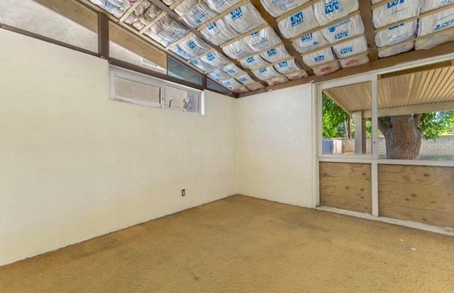 spare room with carpet floors and vaulted ceiling