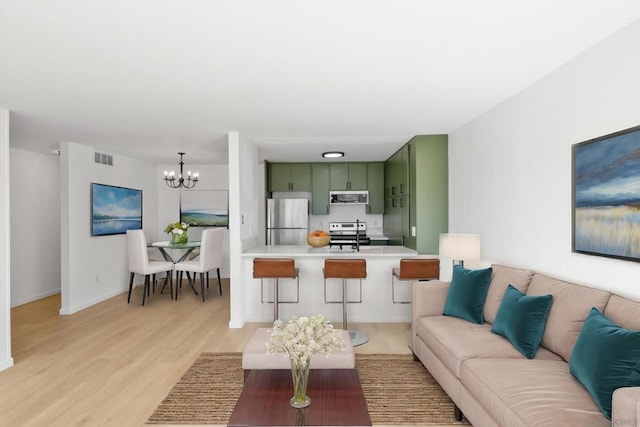 living room featuring a chandelier and light hardwood / wood-style floors